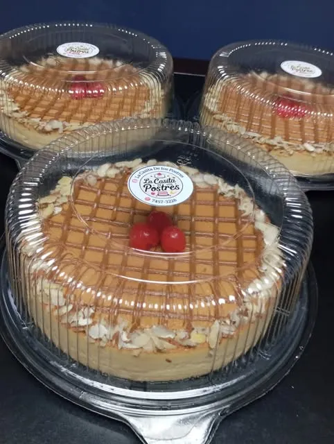 Tres flanes napolitanos enteros con enrejado de caramelo y cerezas, bajo domos con la etiqueta de La Casita